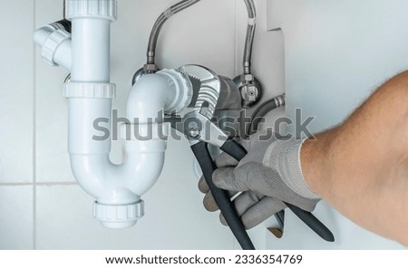 Plumber clearing or unclogging the clogged sink drain siphon. Home insurance for maintenance and repair water leakages and other emergency breakdowns. Plumbing and troubleshooting concept. Royalty-Free Stock Photo #2336354769