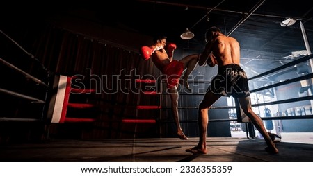 Asian and Caucasian Muay Thai boxer unleash knee attack in fierce boxing training session, delivering knee strike to sparring trainer, showcasing Muay Thai boxing technique and skill. Spur Royalty-Free Stock Photo #2336355359