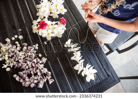Lei making using beautiful flowers on one of the islands of Hawaii Royalty-Free Stock Photo #2336374231