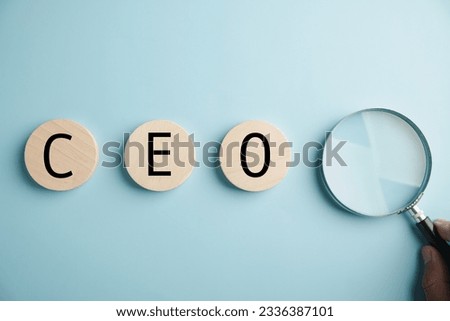 Magnifying glass, Human resources officer finds leader and CEO. HR manager selects employee. HR, HRM, HRD concepts. Circle wooden sign with CEO text. The photo illustrates talent search in HR.