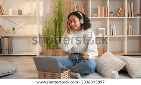 Music joy. Song listening. Audio gadget. Happy woman enjoying favorite playlist in headphones wired to laptop sitting floor in home room. Royalty-Free Stock Photo #2336393897