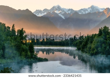 First light of the day at the beautiful Lake Matheson with some mist around the lakeshore Royalty-Free Stock Photo #2336421431