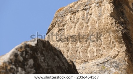 Petroglyphs on rock at Gobustan Rock Art Cultural Landscape in Azerbaijan. Royalty-Free Stock Photo #2336454369