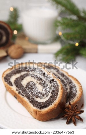 Slices of poppy seed roll and anise star on plate, closeup with space for text. Tasty cake