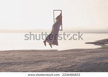 surreal journey of a woman who through a frame passes from the real world to the virtual one, concept of metaverse Royalty-Free Stock Photo #2336486833