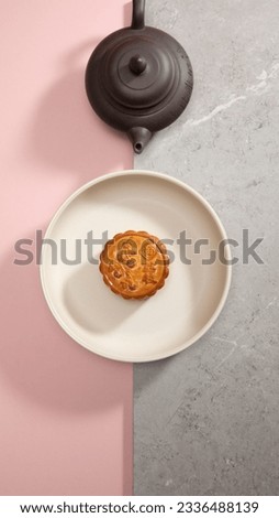 traditional gourmet home made baked and snow skin egg yolk durian moon cake on cute pink background tea pot concept for Chinese mid autumn festival celebration dessert pastry menu halal food in asian