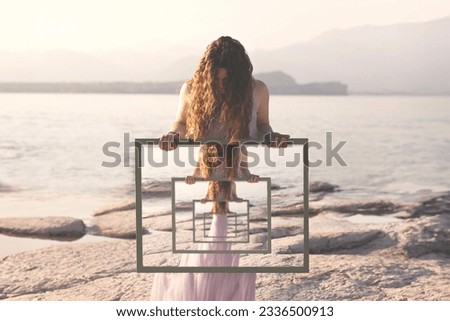 woman holding a surreal frame with the reflection of herself in loops, abstract concept Royalty-Free Stock Photo #2336500913