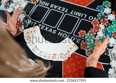 female croupier's hands are taking play card at poker table in casino. Gambling concept