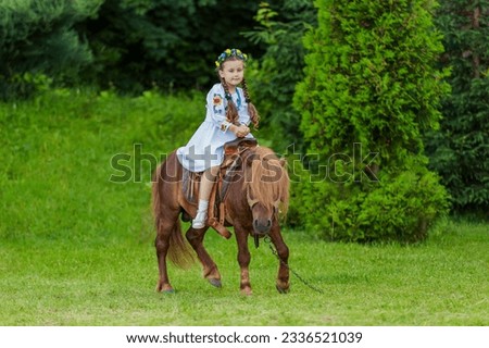 little girl riding a pony