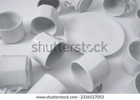 White ceramic plates and coffee cups on a white background                               
