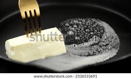 Cube of butter melting sizzling. Butter melting sizzling in frying pan  Royalty-Free Stock Photo #2336533691