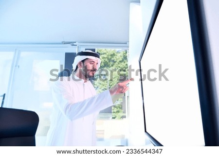 Arab Emirati touch an Interactive touch screen inside an office.