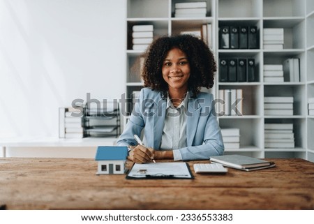 Guarantee, Mortgage, agreement, contract, Signing,woman african american client holding pen to reading agreement document to sign land loan with real estate agent or bank officer, insurance concepts. Royalty-Free Stock Photo #2336553383