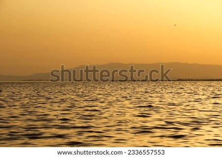 very nice orange yellow tones of sea, water, waves and mountains