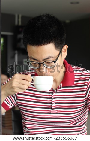 Young man drinking a cup of coffee in coffee shop