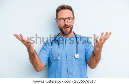 middle age handsome man feeling extremely shocked and surprised. nurse concept