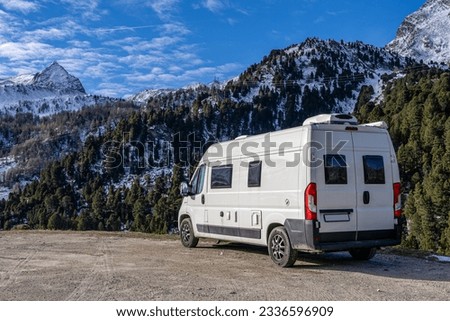 6m long white camper van in the mountains. The Camper is parked in an unpaved square and you can see the rear and the left side. The VanLife in the mountains in Switzerland. Royalty-Free Stock Photo #2336596909