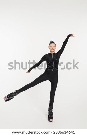 jumping boots, white background, sportswoman in black jumpsuit and kangoo jumping shoes