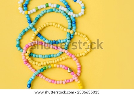 Kids handmade beaded jewelry. Necklaces and bracelets made from multicolored beads and pearls. DIY bracelet beads. Children's needlework. Creativity and hobby. Art activity for kids Royalty-Free Stock Photo #2336635013