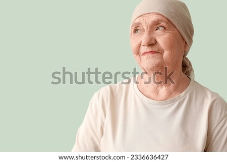 Senior woman after chemotherapy on green background