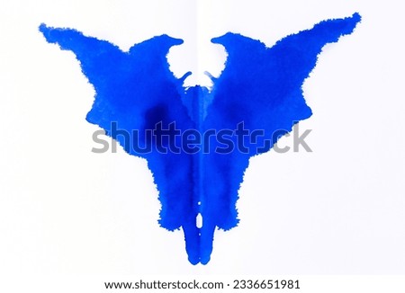Spread blue fountain pen ink blot on white paper making a strange satanic face resembling goat head.