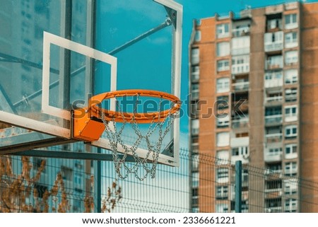 Outdoor basketball backboard and hoop rim with chain net in urban residential district, selective focus