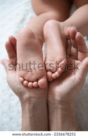 Feet of a newborn from the palms of the parents. Photographing the toes, heels and feet of the child