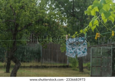 washed clothes in summer rain get wet again Royalty-Free Stock Photo #2336683973
