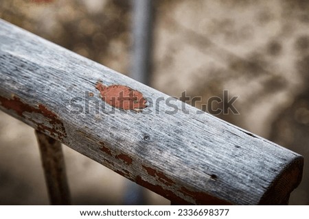 Spot of old paint on worn-out gray wooden railings. Abstract background, texture, frame, copy space