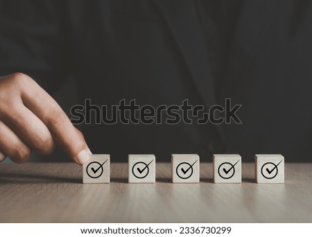 Businessman selecting a wooden cube Put a checkmark in the checkbox. Nan thought about the success of the business. digital marketing business management goals