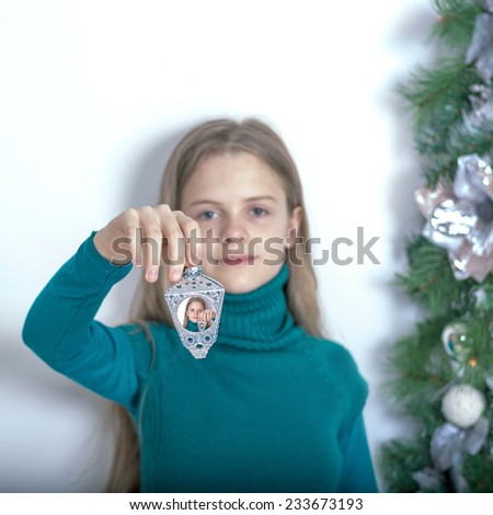 Young girl with a Christmas light. Reiterative picture.