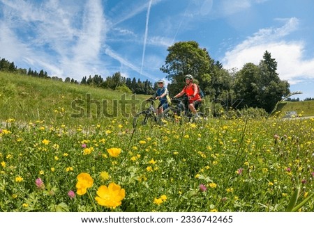 two senior girlfriends having fun during a cycling tour in the Allgau Alps near Oberstaufen, Bavaria, Germany Royalty-Free Stock Photo #2336742465