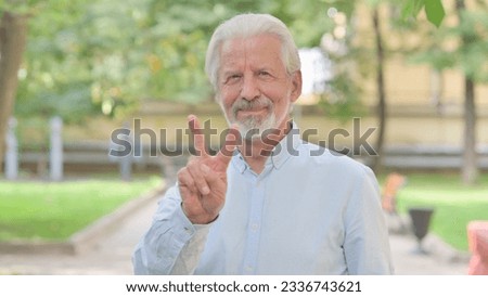 Outdoor Portrait of Senior Old Man Showing sing of Victory