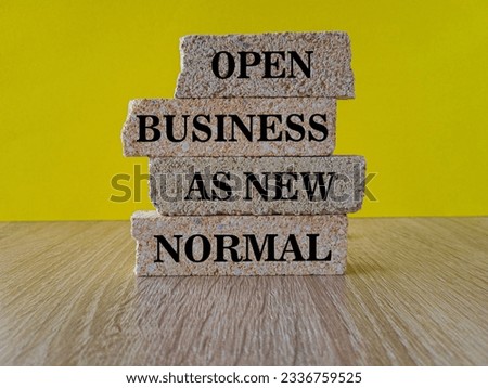 Reopening for business adapt to new normal in the novel Coronavirus COVID-19 pandemic. OPEN BUSINESS AS NEW NORMAL on brick blocks. Beautiful yellow background. Business OPEN BUSINESS AS NEW NORMAL