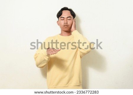 dancing gesture viral on social media Indonesian man wearing yellow sweater on isolated white background. disc jokey gesture. Asians dancing to "If We Ever Broke Up"