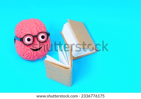 Adorable human brain character adorned with googly eyes and nerdy glasses, immersed in reading, radiating a passion for literature and the pursuit of knowledge.