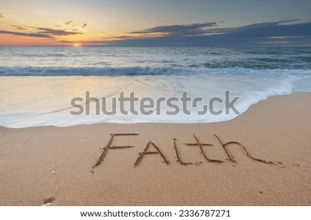 Faith word on the sea shore during sunset. Nature and conceptual scene.