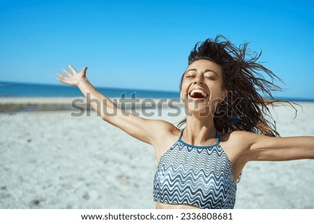 Portrait happy latin hispanic young woman with arms outstretched feeling the breeze at beach. Feeling good, expressive emotions