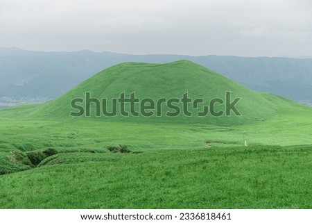 Komezuka or Mt. Kishima of Mount Aso or Aso-san from Kusasenri Observatory area. Mt.Aso with grass along into the mount Royalty-Free Stock Photo #2336818461