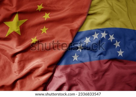 big waving national colorful flag of china and national flag of venezuela . macro