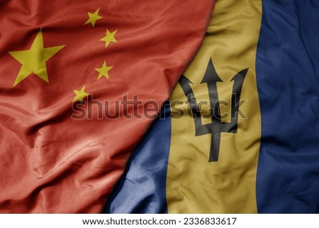 big waving national colorful flag of china and national flag of barbados . macro