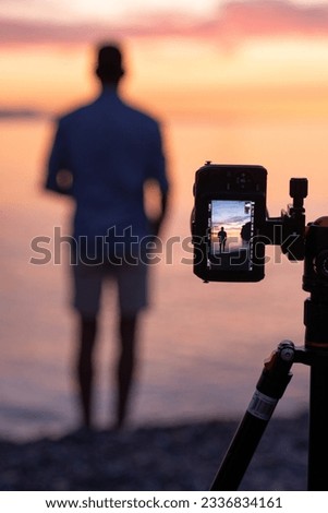 photographer with on the beach at sunset