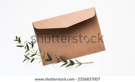 Minimal composition,mockup for greeting card or holiday invitation,flat lay,copy space.Brown craft envelope,blank card for text,eucalyptus branch.Wedding invitation,christening,birthday,love letter