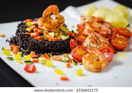 Black Venus rice, prawns, mixed vegetables (carrots, zucchini, peppers), cherry tomatoes, potatoes, cuttlefish, and squid served as a single dish with a black background and a white plate