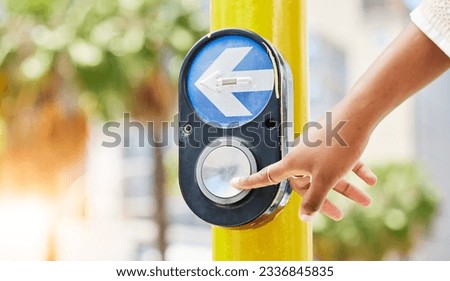 Crosswalk, arrow and button with hand of woman in city for traffic light, intersection and safety. Travel, sign and stop with person at pedestrian crossing in street for press, transport and warning Royalty-Free Stock Photo #2336845835