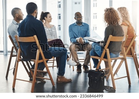 Gathered round for a meeting. Shot of a group of diverse creative employees having a meeting inside. Royalty-Free Stock Photo #2336846499