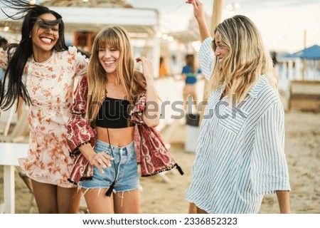 Happy girls having fun while dancing at beach party - Summer vacation, travel and tourist lifestyle concept - Main focus on right female face Royalty-Free Stock Photo #2336852323