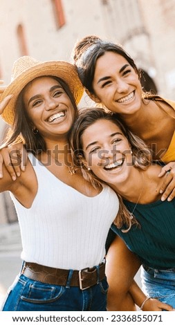 Vertical shot of multiethnic group of three happy young women having fun on summer vacation. Diverse female friends laughing together during their holidays. Female friendship concept. Royalty-Free Stock Photo #2336855071