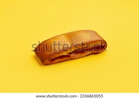 Lanche misto traditional portuguese sandwich with cheese and chorizo. Tasty breakfast over yellow background.