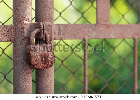 old, rusty padlock on the gate  Royalty-Free Stock Photo #2336865711